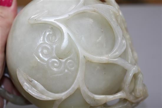 A Chinese pale celadon jade lotus cup, late Ming dynasty, W.13cm, associated wood stand